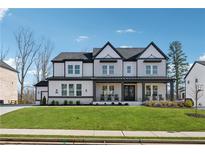 Charming two-story home with a manicured lawn and inviting, covered front porch at 7560 Wild Violet Dr, Cumming, GA 30040