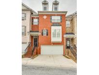 Charming red brick townhouse with a two-car garage and wrought iron stair railing at 215 Aldridge Pl # 9, Smyrna, GA 30082