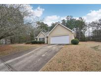 Traditional exterior of a one-story home featuring a driveway and attached two-car garage at 85 Windward Dr, Covington, GA 30016