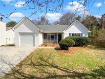 Charming single-story home features a well-manicured lawn, white siding, and an attached one car garage at 10632 Pine Forest Ne Ln, Jonesboro, GA 30238