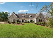 Charming stone-accented home featuring a manicured lawn and mature landscaping at 5515 Punkintown Rd, Douglasville, GA 30135