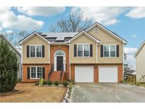 Charming two-story home with a brick and siding exterior and a well-manicured lawn with beautiful brick stairs at 960 Sugar Meadow Dr, Sugar Hill, GA 30518