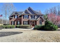 Elegant brick home with a well-kept lawn and lush shrubbery, presenting great curb appeal at 5030 New Chapel Hill Way, Cumming, GA 30041