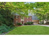 Traditional two-story brick home boasts a lush green lawn and attached two car garage at 1061 Steeple Run, Lawrenceville, GA 30043