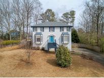 Charming two-story home features a vibrant blue door, bay windows, and a well-maintained front yard at 4646 Breakwater Trl, Marietta, GA 30066