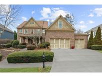 Beautiful two-story brick home featuring a three-car garage, manicured lawn, and covered front porch at 4620 Westgate Dr, Cumming, GA 30040