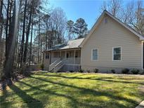 Charming single-story home with a covered front porch and a well-maintained lawn at 2087 Blackberry Ln, Auburn, GA 30011