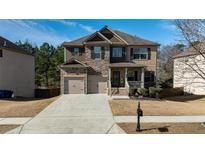 Beautiful two-story home boasts a combination of brick and stone accents, attached two-car garage and a welcoming front porch at 784 Sunset Down Ct, Loganville, GA 30052