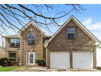 Charming brick two-story home with attached two car garage and manicured lawn at 1935 Cutters Mill Way, Lithonia, GA 30058
