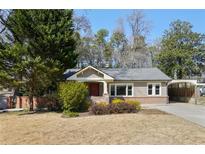 Charming single-story home featuring a landscaped yard, brick accents, and a covered carport at 2592 Valley Stream Dr, Atlanta, GA 30360