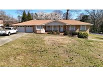 Charming brick ranch home with a spacious front yard, attached two-car garage, and well-maintained landscaping at 3401 Doyle Sw Ln, Marietta, GA 30060