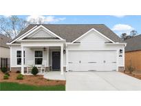 Charming single-story home featuring a two-car garage, covered porch, and beautifully landscaped front yard at 1235 Cedarcrest Blvd, Acworth, GA 30101