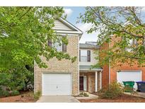 Charming two-story brick home with attached one-car garage and mature trees in front at 1624 River Main Ct, Lawrenceville, GA 30046