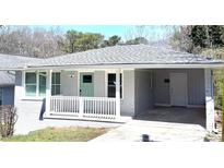 Charming home featuring a freshly painted exterior, covered carport, and light green front door at 2405 Cross Nw St, Atlanta, GA 30318