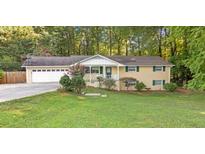Charming ranch-style home with an attached garage and a well-maintained front lawn and mature trees at 2892 Cardinal Lake Dr, Duluth, GA 30096