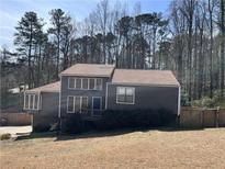 Charming two-story home with a front porch and large windows surrounded by mature trees at 700 Bayliss Dr, Marietta, GA 30068