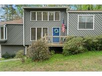 Charming gray home featuring a blue front door with an American flag and neatly landscaped yard at 700 Bayliss Dr, Marietta, GA 30068