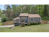 Charming home featuring a front yard, a wooden fence, and a blue door with an American flag at 700 Bayliss Dr, Marietta, GA 30068