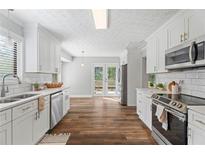 Bright kitchen featuring white cabinets, stainless steel appliances, and modern countertops at 700 Bayliss Dr, Marietta, GA 30068