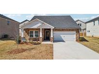 Charming single Gathering home with brick and white accents and an attached two car garage at 6902 Winchester Pl, Fairburn, GA 30213