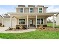 Inviting two-story home with a charming front porch and well-manicured lawn at 1340 Slaton Manor Dr, Conyers, GA 30012