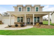 Charming two-story home featuring a welcoming front porch with stone accents and a well-manicured lawn at 1340 Slaton Manor Dr, Conyers, GA 30012