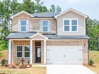 Charming two-story home with brick facade, gray siding, a two-car garage, and manicured front yard at 6897 Plymouth Dr, Fairburn, GA 30213