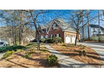 Charming two-story brick home featuring a well-manicured front yard with mature trees at 5679 Brookstone Nw Walk, Acworth, GA 30101