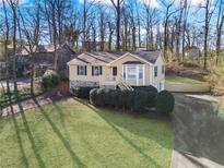 Charming home boasts a well-manicured lawn, stone accents, and inviting front porch with stairs at 1184 Broward Ne Dr, Marietta, GA 30066