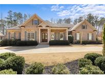 Charming, single-story brick home with well-manicured landscaping and a welcoming front porch at 209 Windsor Green Ct, Canton, GA 30115