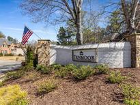 Welcoming stone-and-brick entrance sign featuring manicured landscaping and a flagpole with the American flag at 10815 Centennial Dr, Alpharetta, GA 30022