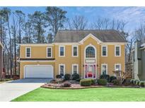 Charming two-story home with a manicured lawn, two car garage and mature landscaping at 1220 Lochshyre Way, Lawrenceville, GA 30043