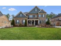 Charming two-story brick home with a manicured lawn and inviting front porch at 1620 Copperleaf Nw Ct, Kennesaw, GA 30152