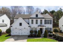 Charming two-story home with a well-manicured lawn, two-car garage, and white painted brick at 3590 Davyne Bnd, Cumming, GA 30040