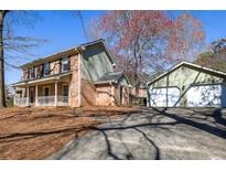 Charming two-story brick home featuring an inviting front porch and separate garage at 4210 Gladney Dr, Atlanta, GA 30340