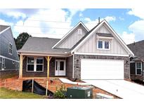Charming single-story home featuring brick accents, attached garage, and a covered front porch at 138 Laurel Farms Ln, Dallas, GA 30157