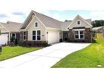 Charming single-story home featuring a manicured lawn, stone accents, and a two-car garage at 125 Laurel Farms Ln, Dallas, GA 30157