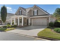 Charming home showcasing a well-manicured lawn, inviting entrance, and a convenient two-car garage at 3470 Serenade Nw Commons, Kennesaw, GA 30152