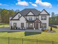 Stunning two-story home with a modern white exterior, black trim, and a lush green lawn at 1011 Nours Cir, Lawrenceville, GA 30045