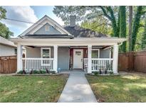 Charming home featuring a welcoming front porch with rocking chairs and well-maintained landscaping at 833 N Grand Nw Ave, Atlanta, GA 30318