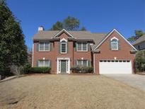 Charming brick home featuring a well-manicured lawn and a two-car garage at 9560 Knollcrest Blvd, Alpharetta, GA 30022