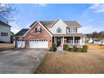 Charming two-story brick home with a welcoming front porch and a well-manicured lawn at 1191 Fountain Head Ct, Lawrenceville, GA 30043