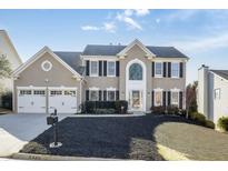 Charming two-story home with a well-manicured lawn and a two-car garage, all under a clear blue sky at 5446 Oxford Chase Way, Dunwoody, GA 30338