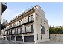 Modern townhome with painted brick, black trim, balconies, and attached garages at 574 Boulevard Ne Pl # 5, Atlanta, GA 30308