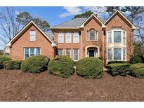 Beautiful brick home with a manicured lawn and lush landscaping, creating a welcoming curb appeal at 1780 Redbourne Dr, Sandy Springs, GA 30350