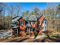 Charming two-story brick home with a well-manicured lawn and mature trees at 2418 Caylor Hill Pte Nw, Kennesaw, GA 30152