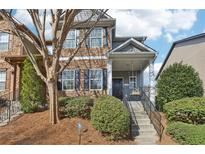 Charming two-story townhome with stone accents, a porch swing, and lush landscaping at 5227 Whiteoak Se Ave, Smyrna, GA 30080