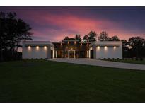 Stunning modern home with manicured lawn and striking architectural design at dusk at 292 Highway 279, Fayetteville, GA 30214
