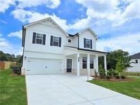 Charming two-story home featuring a well-manicured lawn, attached garage, and inviting front porch at 650 Redhead Way (Lot 25), Grayson, GA 30017