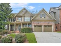 Charming two-story brick home with manicured lawn and attached two car garage at 1331 Ashbury Park Dr, Hoschton, GA 30548